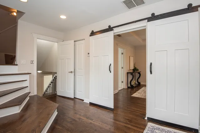 a view of a hallway with wooden floor and closet