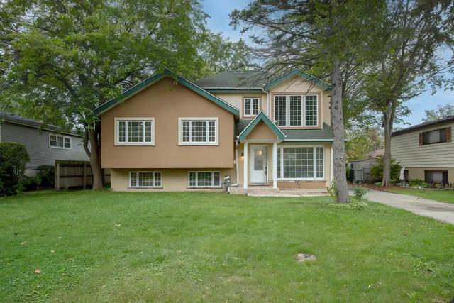 a front view of a house with a yard and trees
