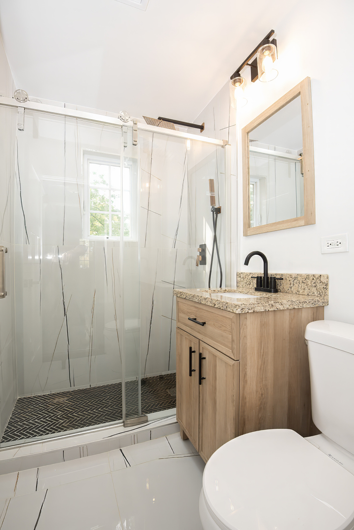 216 Flora Avenue Glenview, IL 60025 - Photo 32 of 40 a bathroom with a sink a mirror and a shower