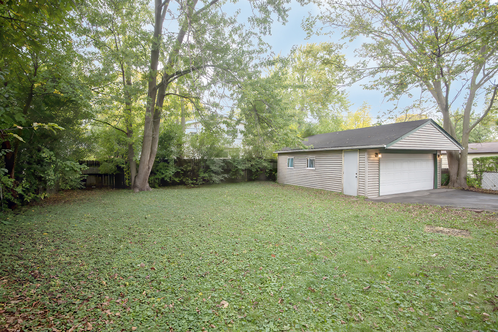 216 Flora Avenue Glenview, IL 60025 - Photo 39 of 40 a view of a backyard with large trees and wooden fence