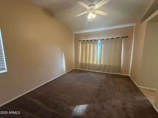 a view of an empty room with a ceiling fan