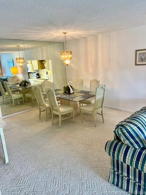 1858 Southwest Palm City Road, Unit 203 Stuart, FL 34994 - Photo 25 of 29 a dining room with furniture and a chandelier