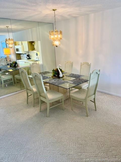 1858 Southwest Palm City Road, Unit 203 Stuart, FL 34994 - Photo 29 of 29 a view of a dining room with furniture and chandelier