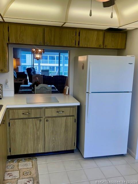 1858 Southwest Palm City Road, Unit 203 Stuart, FL 34994 - Photo 10 of 29 a kitchen with a refrigerator and a more cabinets