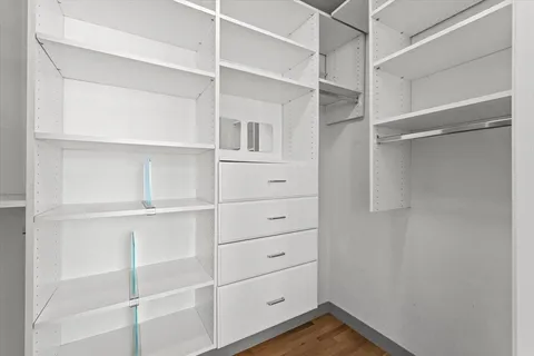 a view of walk in closet with empty racks