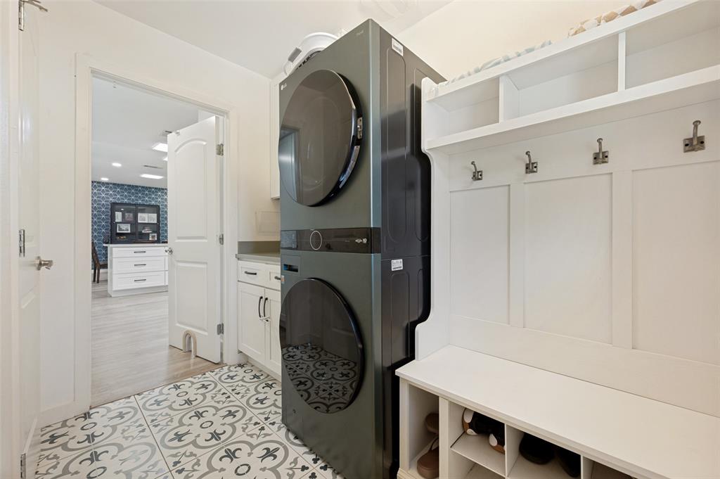 3619 Merrell Road Dallas, TX 75229 - Photo 11 of 26 Mudroom featuring a built-in bench with shoe cubbies, wall hooks, and upper shelving