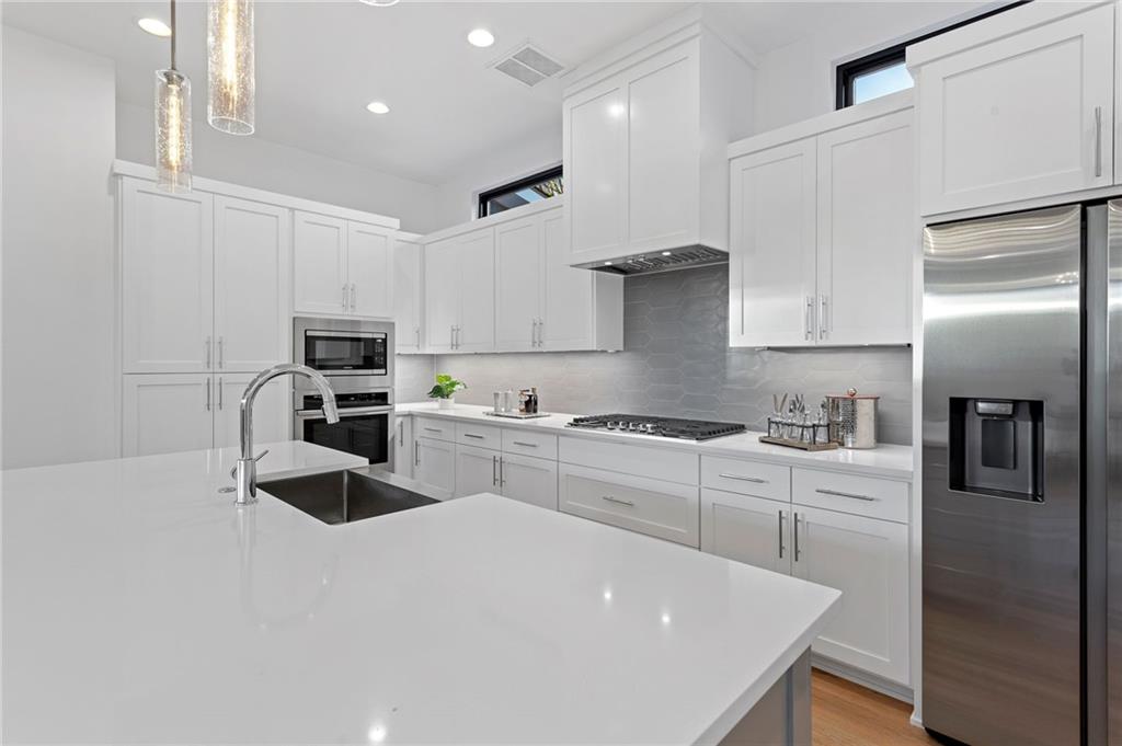 1004 Lott Avenue Austin, TX 78721 - Photo 15 of 39 a kitchen with white cabinets and stainless steel appliances