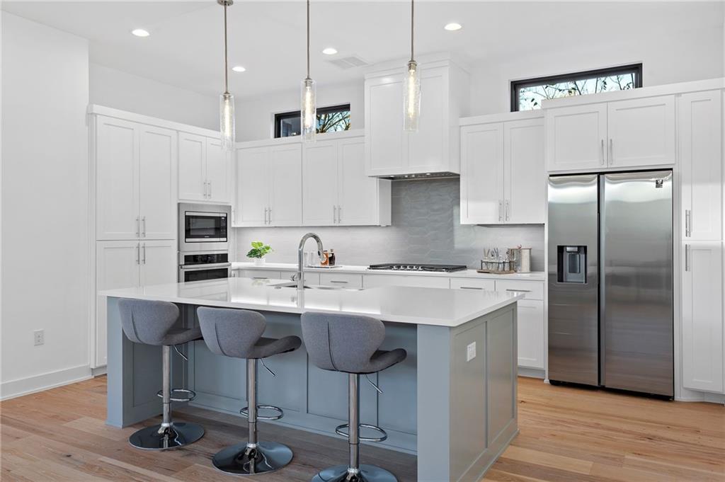 1004 Lott Avenue Austin, TX 78721 - Photo 2 of 39 a kitchen with stainless steel appliances granite countertop a sink a stove a refrigerator and island with wooden floor