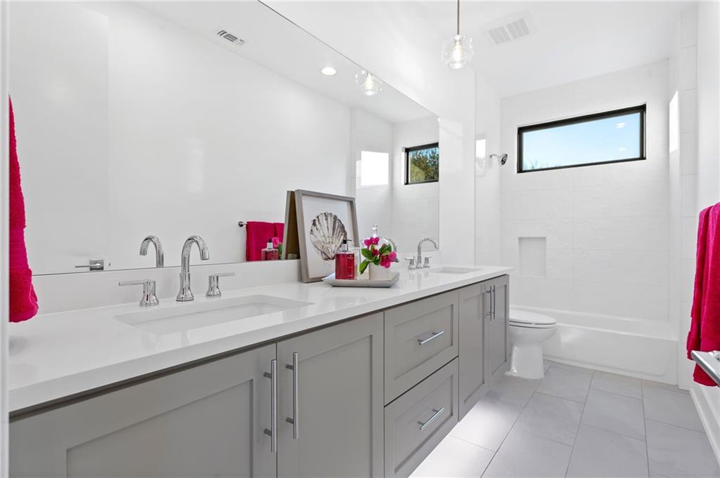 1004 Lott Avenue Austin, TX 78721 - Photo 29 of 39 a bathroom with a double vanity sink and a toilet
