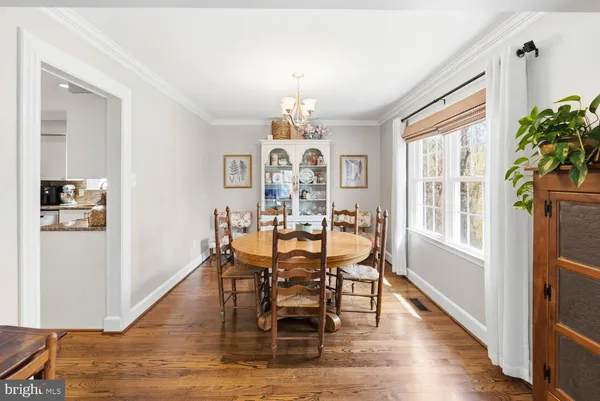 a view of a dining room with furniture a chandelier and wooden floor
