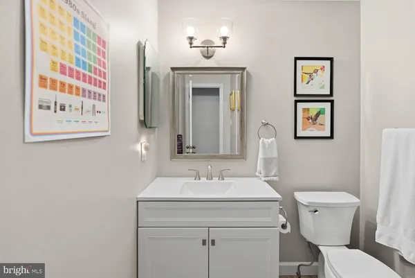a bathroom with a granite countertop sink mirror and toilet