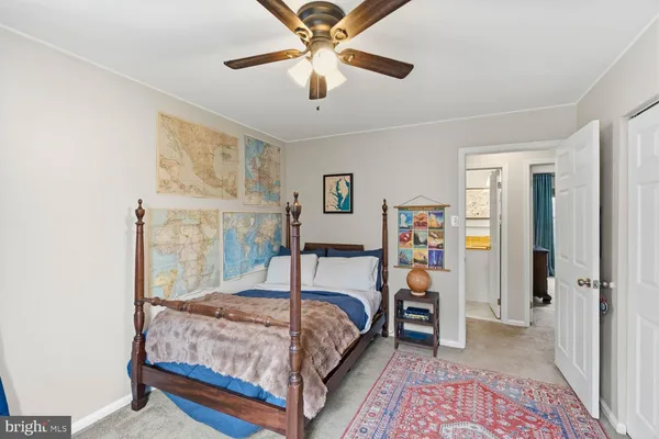 a bedroom with a bed next to a window and a chandelier