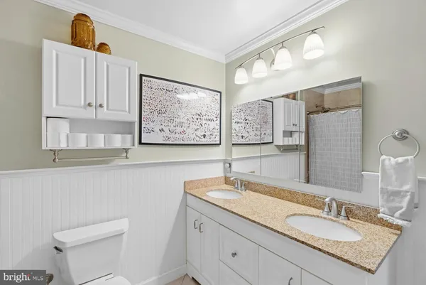 a bathroom with a granite countertop sink a toilet and a mirror