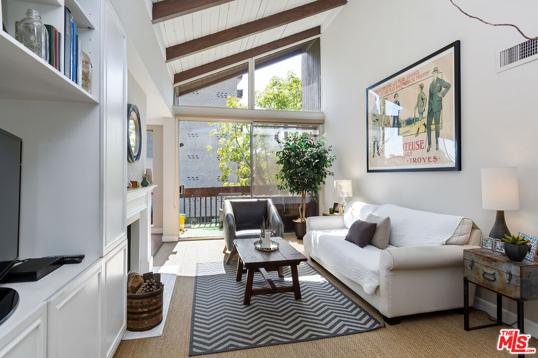 a living room with furniture large window and a flat screen tv