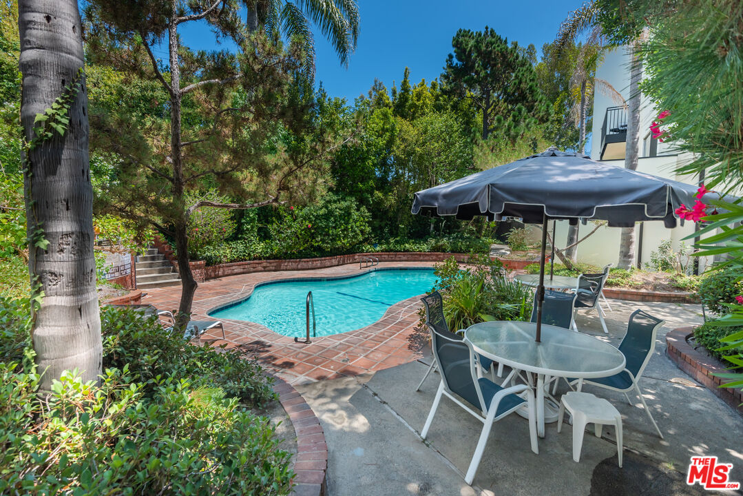 1340 South Beverly Glen Boulevard, Unit 307 Los Angeles, CA 90024 - Photo 17 of 18 a view of a table and chairs under an umbrella