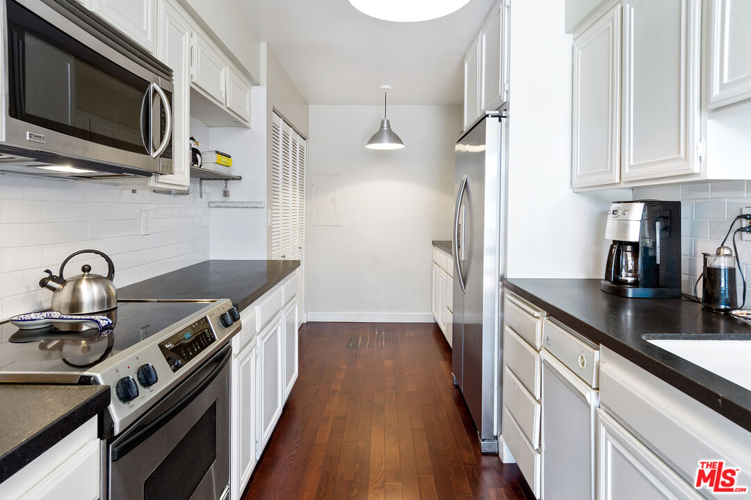 1340 South Beverly Glen Boulevard, Unit 307 Los Angeles, CA 90024 - Photo 6 of 18 a kitchen with stainless steel appliances granite countertop a sink a stove and a refrigerator