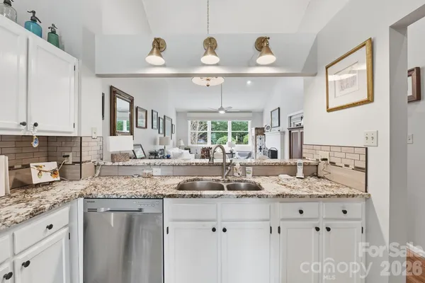 a kitchen with granite countertop a sink stainless steel appliances and cabinets