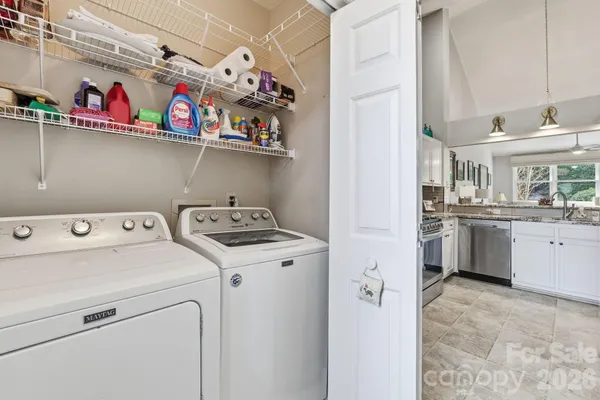 a view of washer and dryer with kitchen in the background
