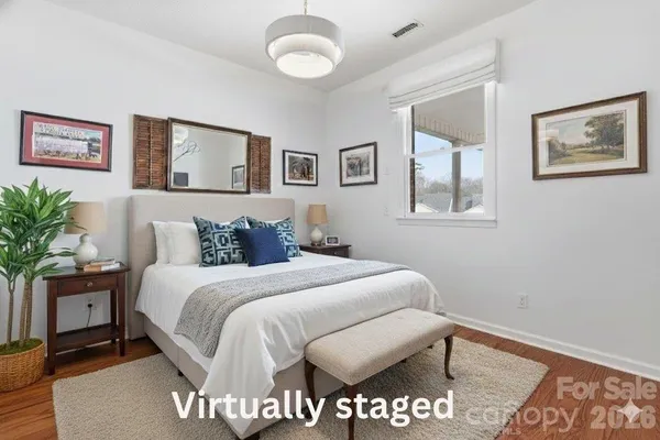 a bedroom with a large bed and a chandelier