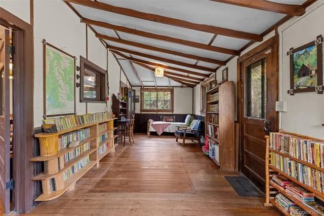 a view of a hallway with wooden floor and stairs