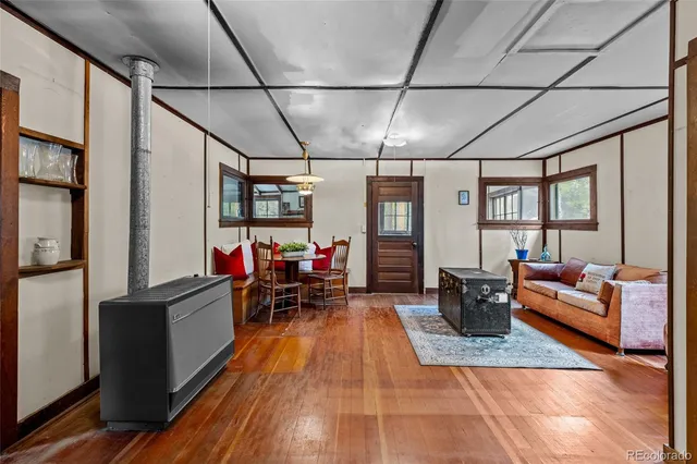 a dining room with furniture a chandelier and wooden floor