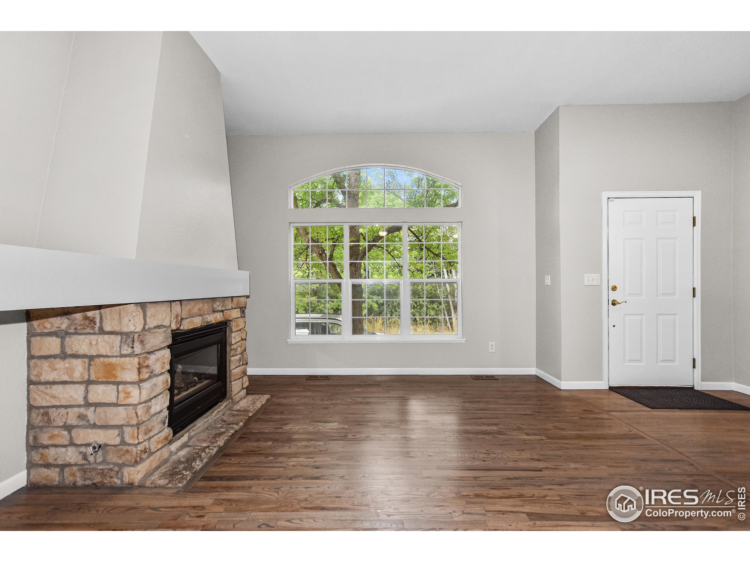 1680 Foxbrook Way Fort Collins, CO 80526 - Photo 13 of 42 a view of an empty room with wooden floor and a window