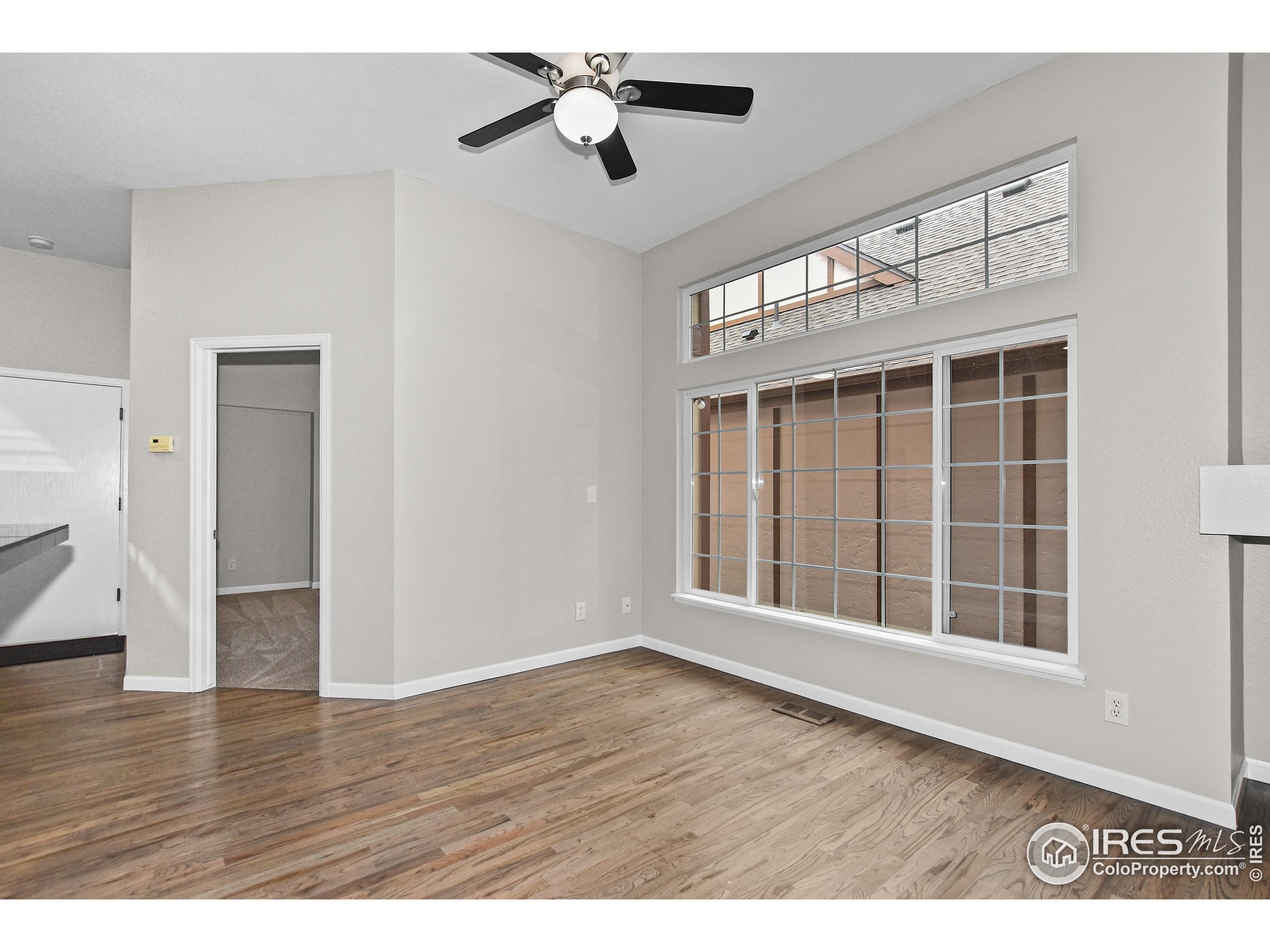 1680 Foxbrook Way Fort Collins, CO 80526 - Photo 15 of 42 a view of an empty room with wooden floor and a window
