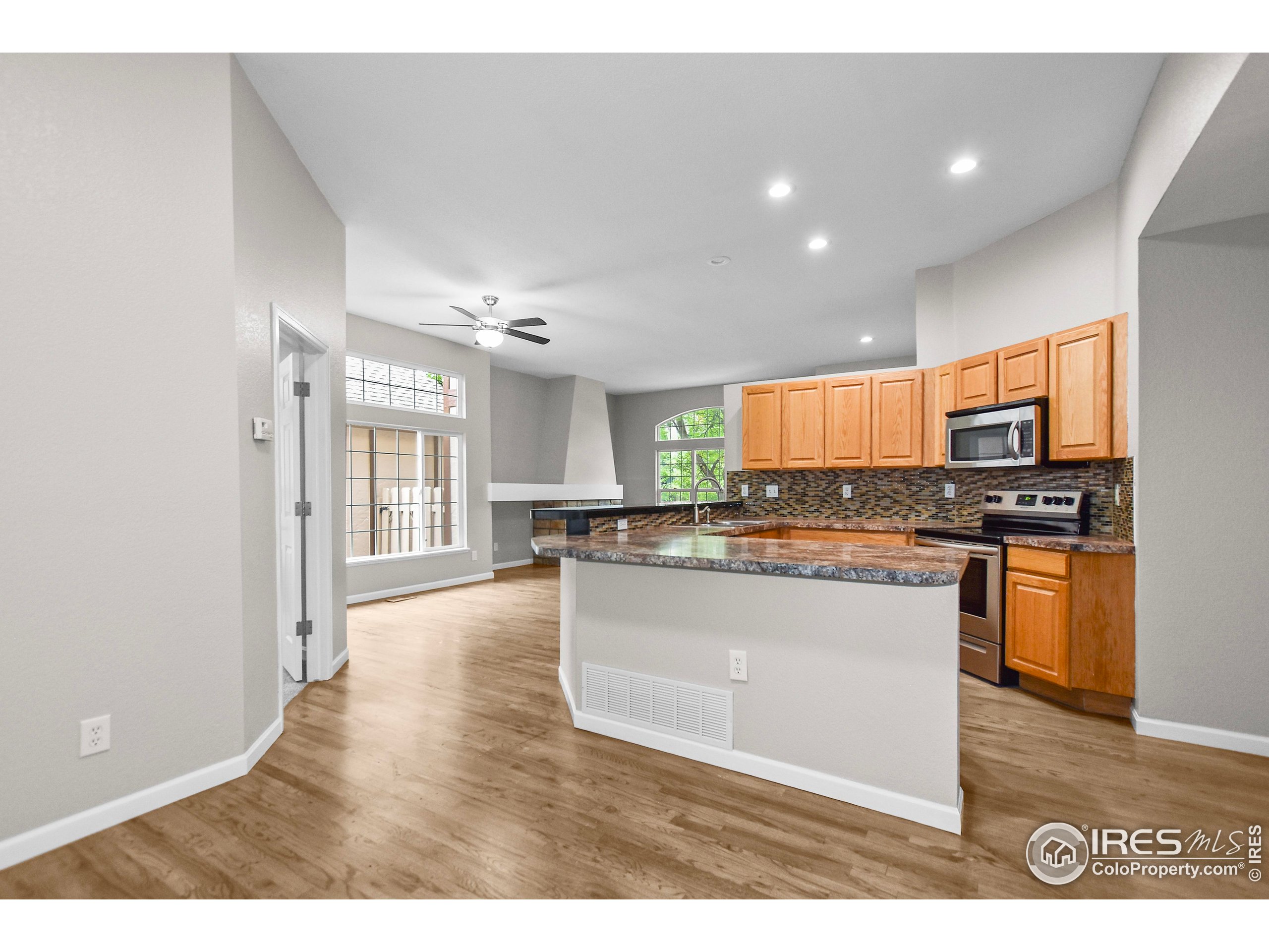 1680 Foxbrook Way Fort Collins, CO 80526 - Photo 19 of 42 a kitchen with stainless steel appliances granite countertop a refrigerator a sink dishwasher a stove and white countertops with wooden floor