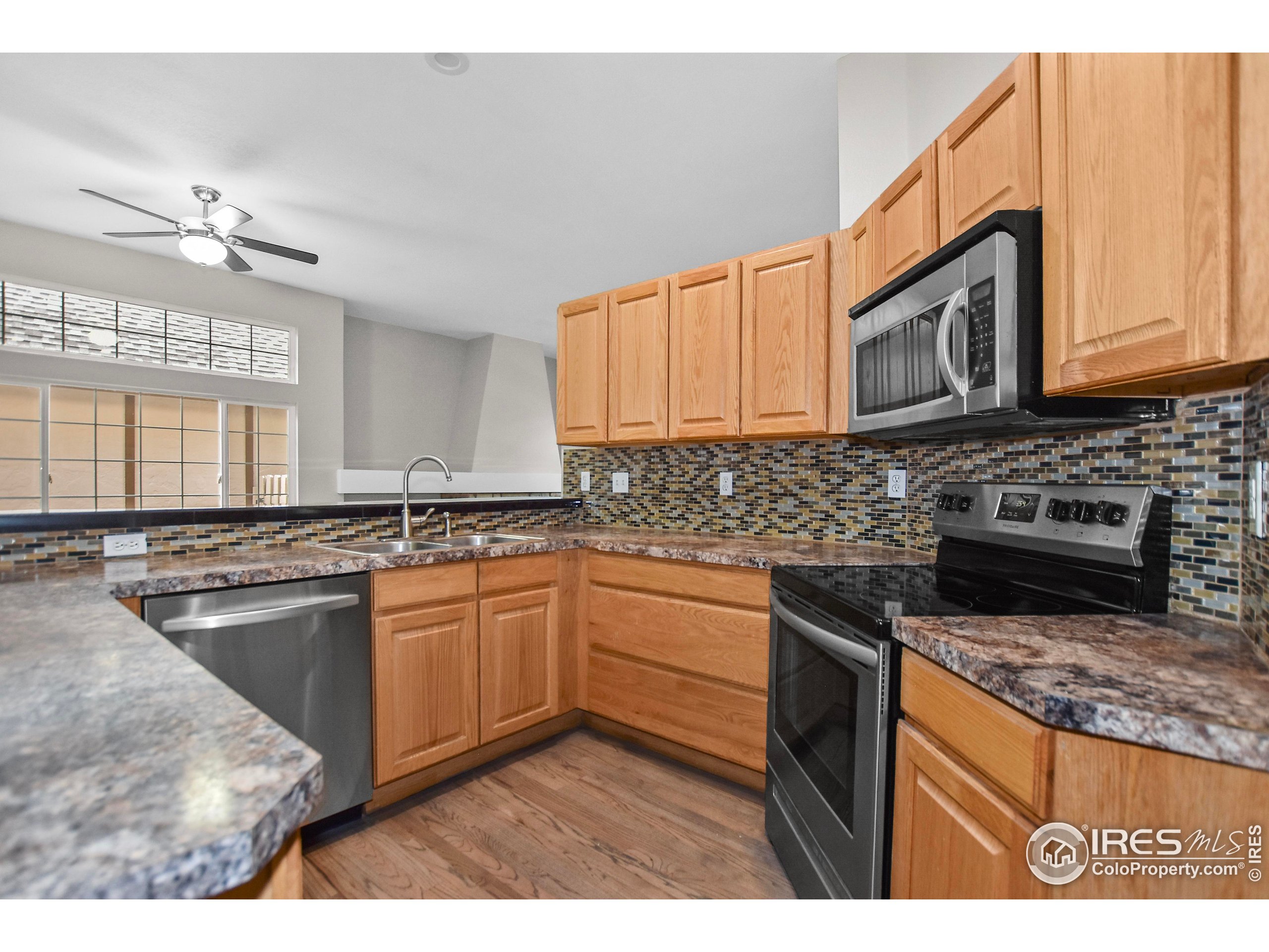 1680 Foxbrook Way Fort Collins, CO 80526 - Photo 21 of 42 a kitchen with stainless steel appliances granite countertop a stove a sink and a microwave