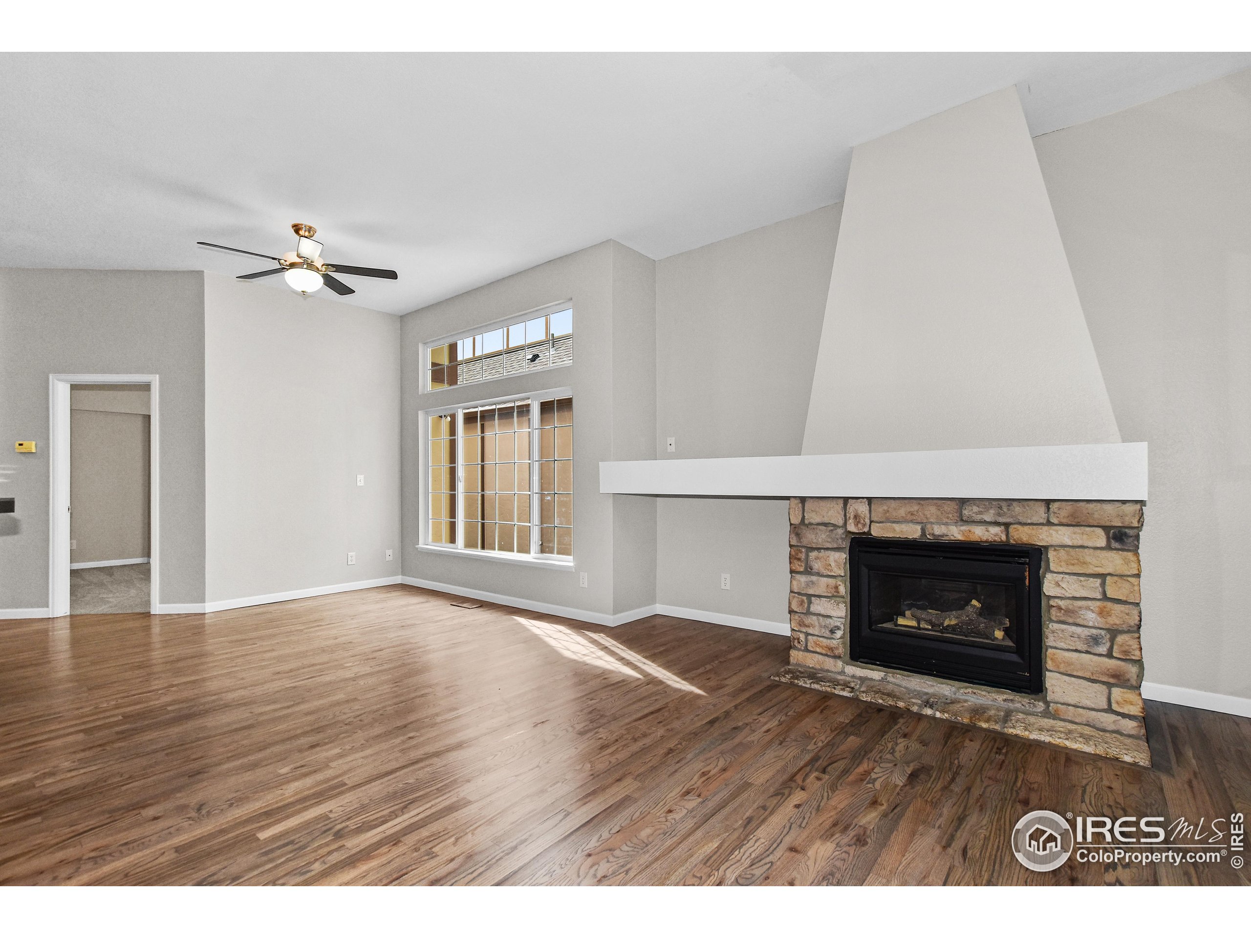 1680 Foxbrook Way Fort Collins, CO 80526 - Photo 9 of 42 a view of an empty room with a fireplace and a window
