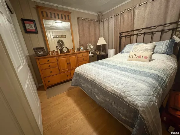 a bedroom with a bed a mirror and a window