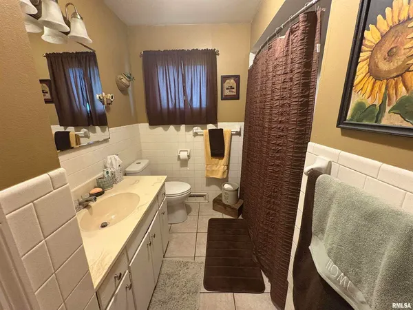 a bathroom with a sink and mirror with bathtub
