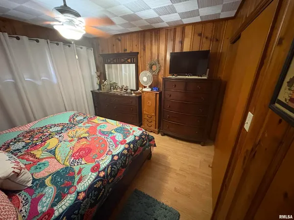 a bedroom with a bed dresser and a window