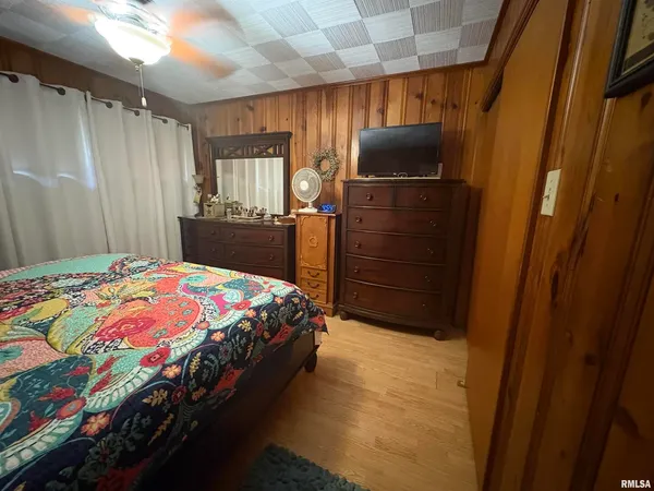 a bedroom with a bed a dresser and a shower