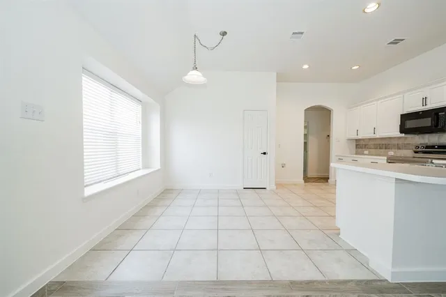 a view of kitchen with granite countertop cabinets and window