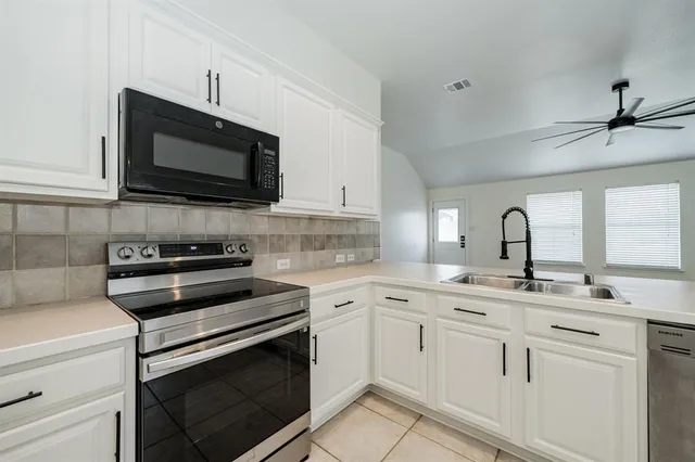 a kitchen with appliances a sink and cabinets