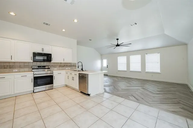 a kitchen with granite countertop white cabinets and white appliances