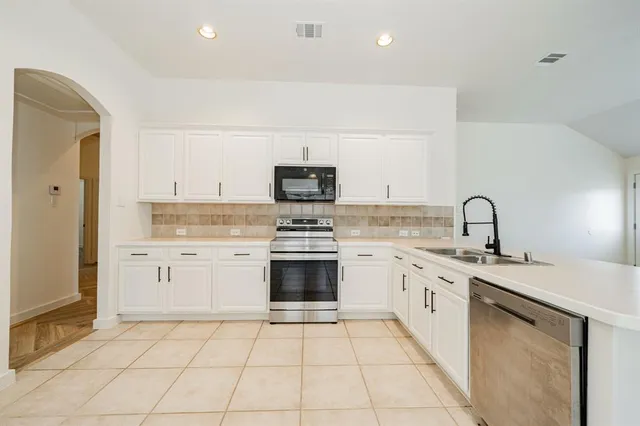 a kitchen with a stove top oven and sink
