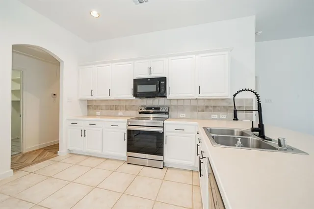a kitchen with a sink stove and cabinets