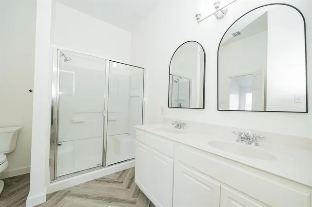 a bathroom with a granite countertop sink a mirror and shower