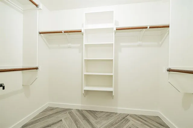 a view of walk in closet with empty racks