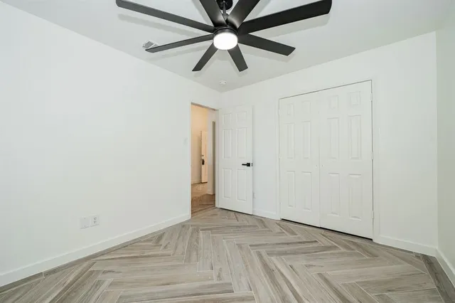 an empty room with a window and a fan