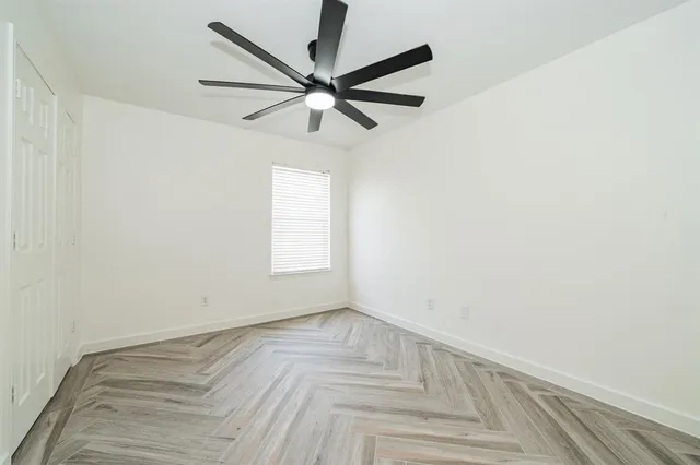 a view of a big room with wooden floor and a ceiling fan