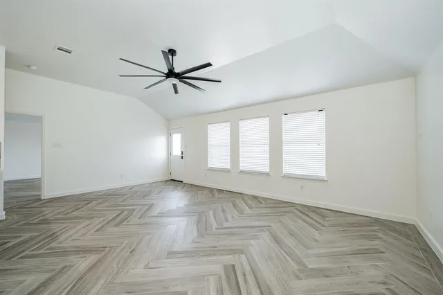 wooden floor in an empty room with a window