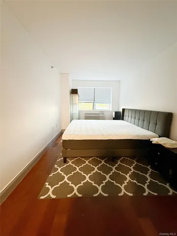 a bedroom with a bed and a lamp on the dresser