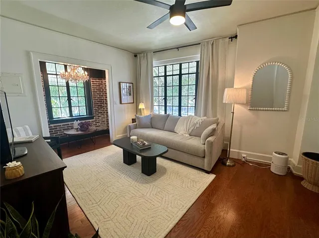 a living room with furniture a window and a flat screen tv