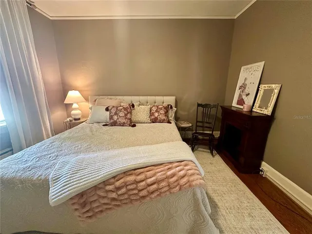 a bedroom with a bed and a lamp on dresser
