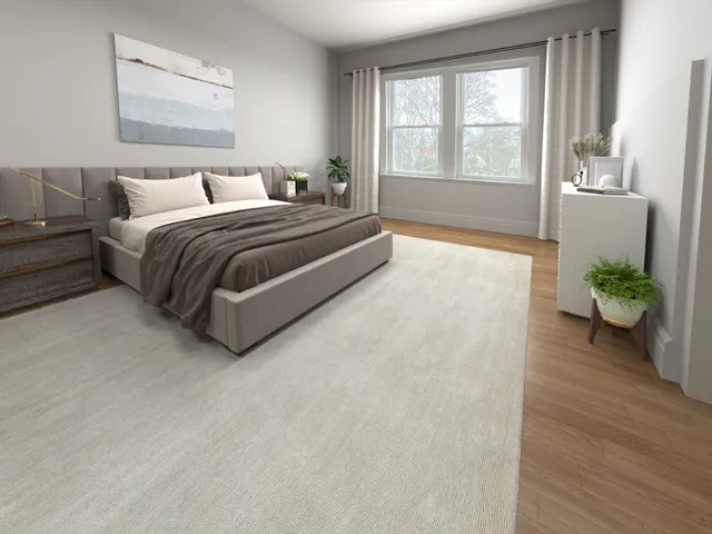 a spacious bedroom with a bed lamp and a large window