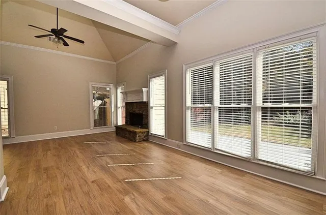 a view of an empty room with a window and wooden floor