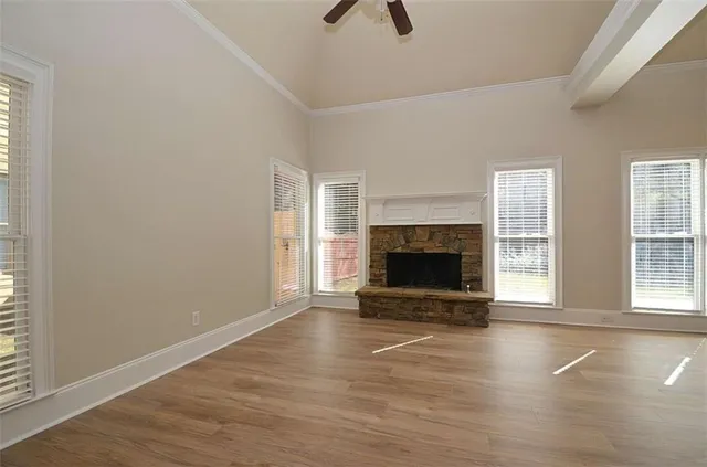 an empty room with floor to ceiling window and fireplace